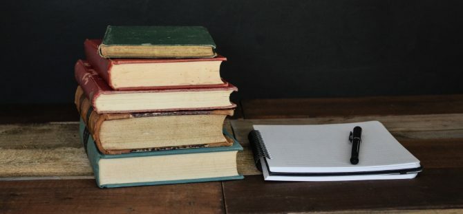 Bunke med bøger og notesblok til forskning